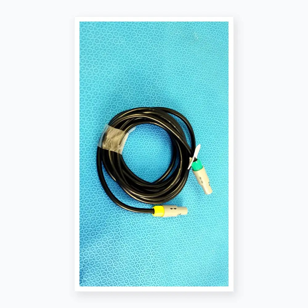 Black coiled catheter connection cable with gray connectors and green and yellow accents for reuse medical equipment