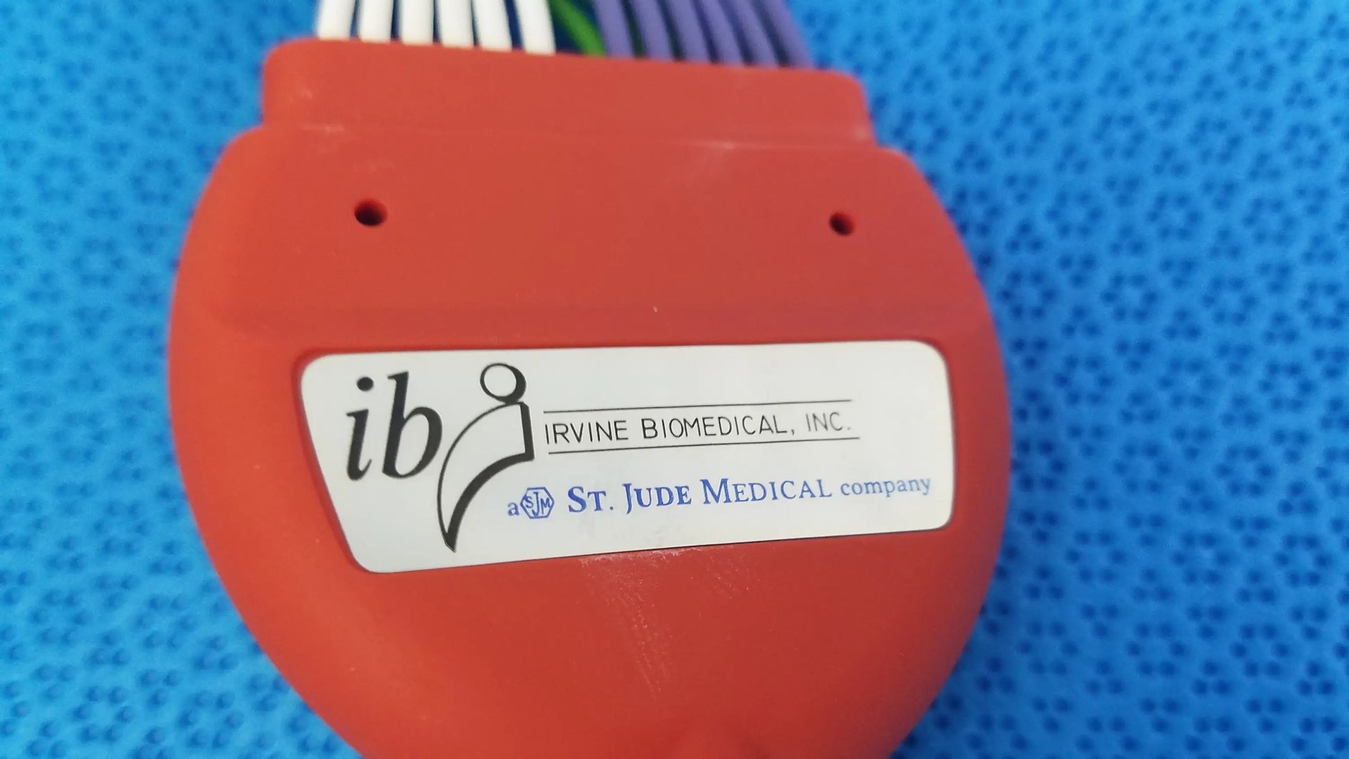 Orange plastic connecting cable with white label featuring ib logo from st jude medical for medical equipment use