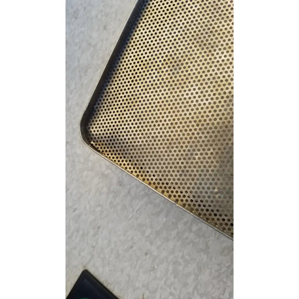 Gold-colored stainless steel sterilization basket tray with uniform perforated circular holes for effective sterilization