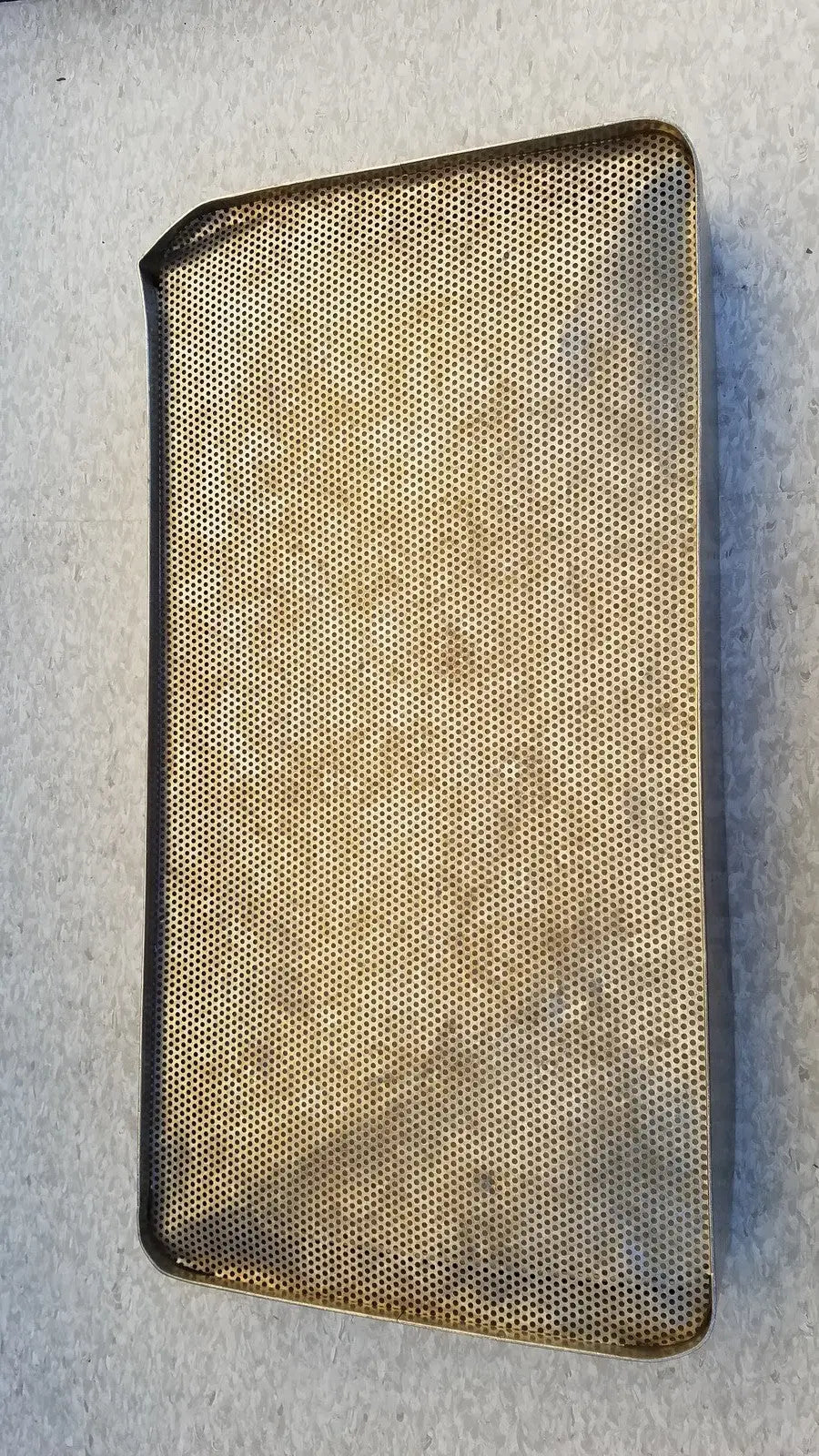 A rectangular gold-toned steel sterilization basket tray with mesh construction and rounded corners for stainless steel sterilization