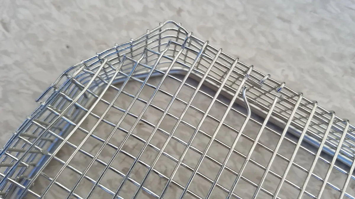 Silver wire mesh basket with rectangular grid and rounded corners for stainless steel sterilization surgical cases