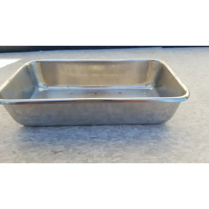 Rectangular stainless steel vollrath sheboygan tray with raised edges and perforated bottom for baking use