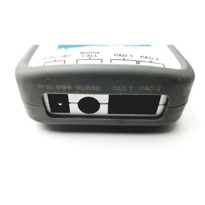 Gray plastic back side of stanley healthcare m200 nurse call unit with labeled ports for dc power nurse call and patient pads