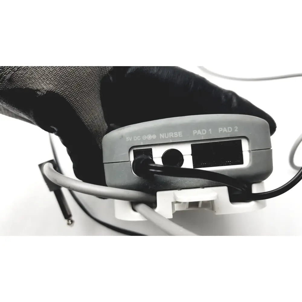 Gray plastic stanley healthcare m200 nurse call unit backside showing labeled ports for nurse and patient pads connectivity