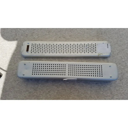 Two white plastic rectangular air vents with perforated surfaces and screws on steel healthcare equipment medical sterilization tray