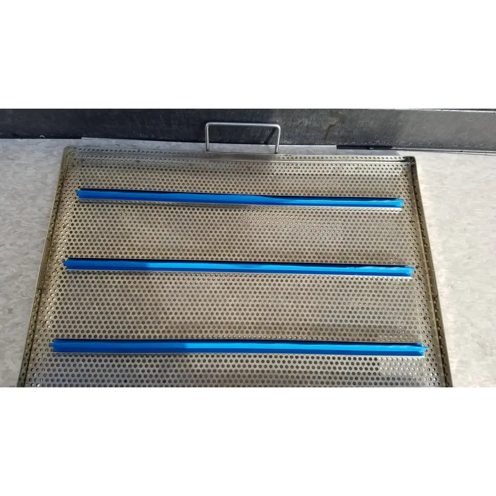 Stainless steel sterilization case tray with perforations and three horizontal blue plastic strips for surgical instruments