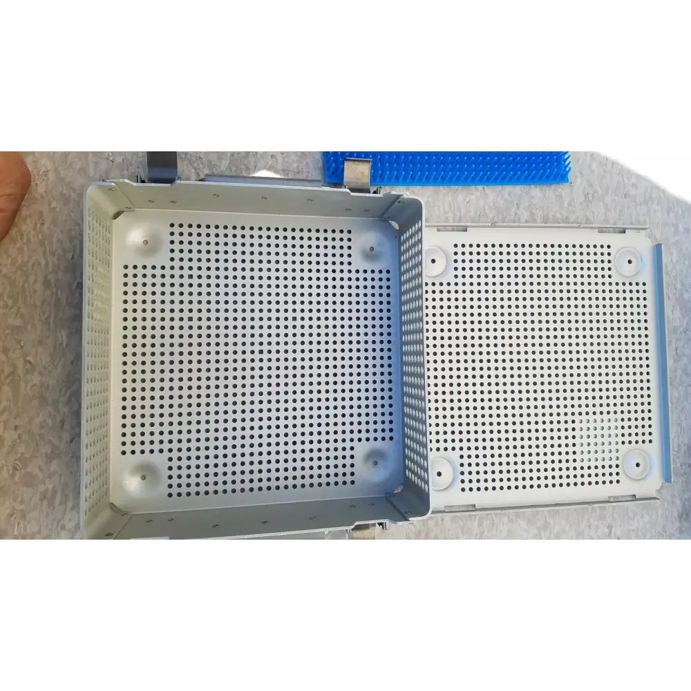 Gray perforated metal sterilization case with reinforced edges and silicone mat for reuse medical instruments