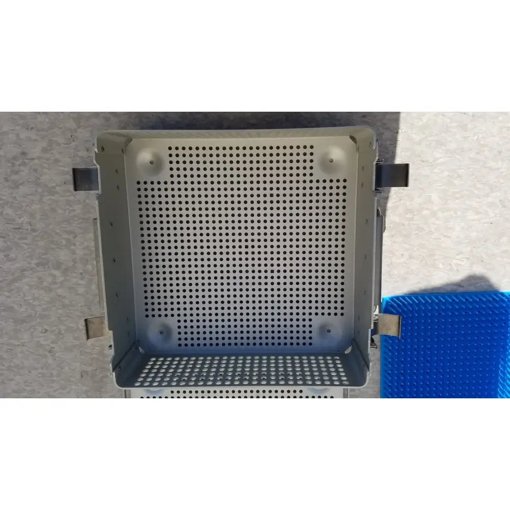 Gray perforated metal sterilization case with reinforced corners, side latches, and silicone mat for reuse medical use