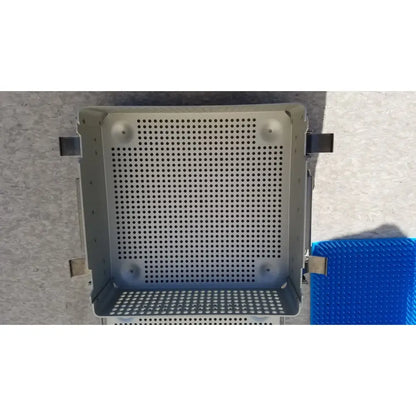 Gray perforated metal sterilization case with reinforced corners, side latches, and silicone mat for reuse medical use