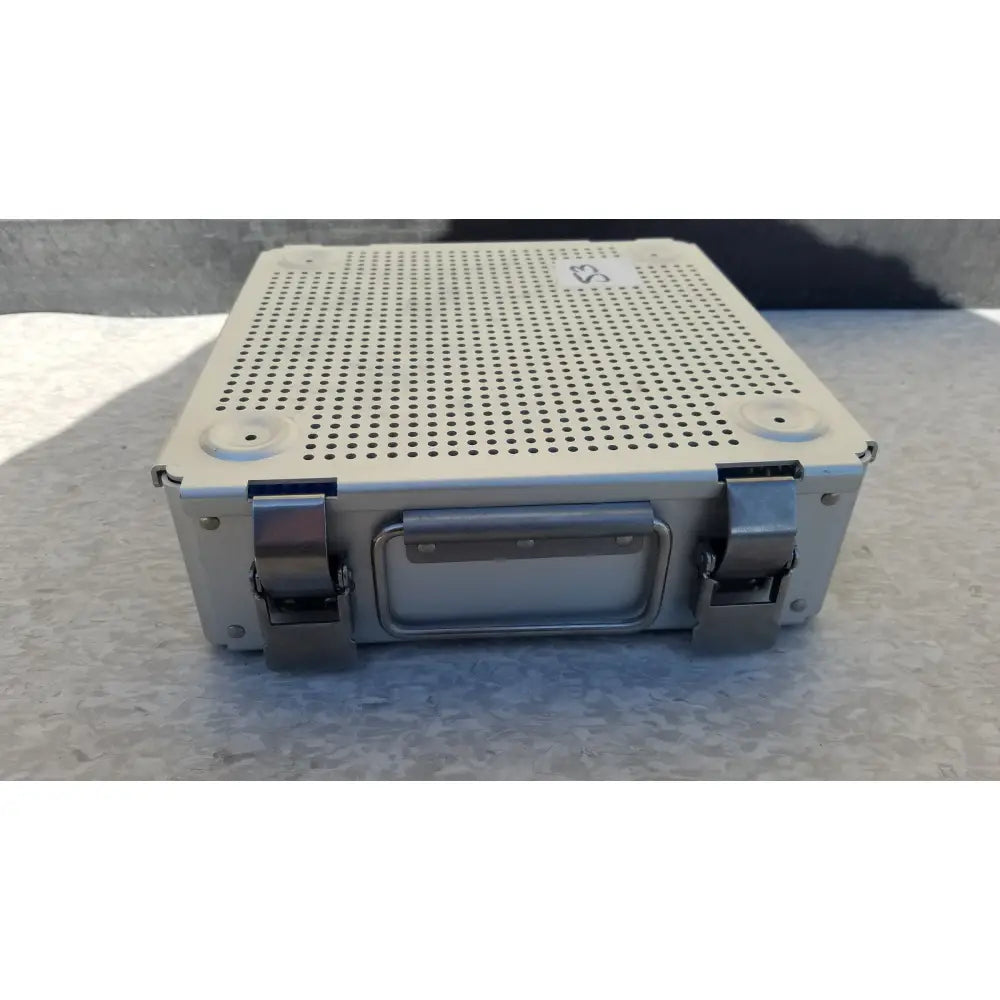 Beige sterilization case with perforated metal top and bottom silver latches handle and silicone mat for reuse medical purposes