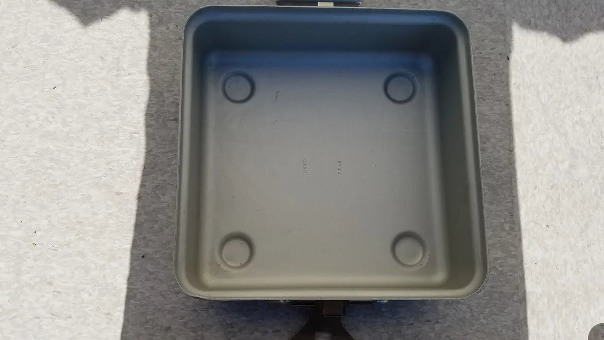 Gray square electric skillet with rounded corners and circular indentations designed for reuse medical sterilization trays