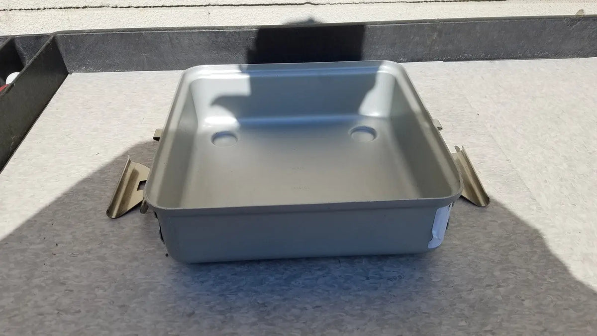 Silver rectangular metal sterilization container without lid featuring rounded corners and two circular indentations