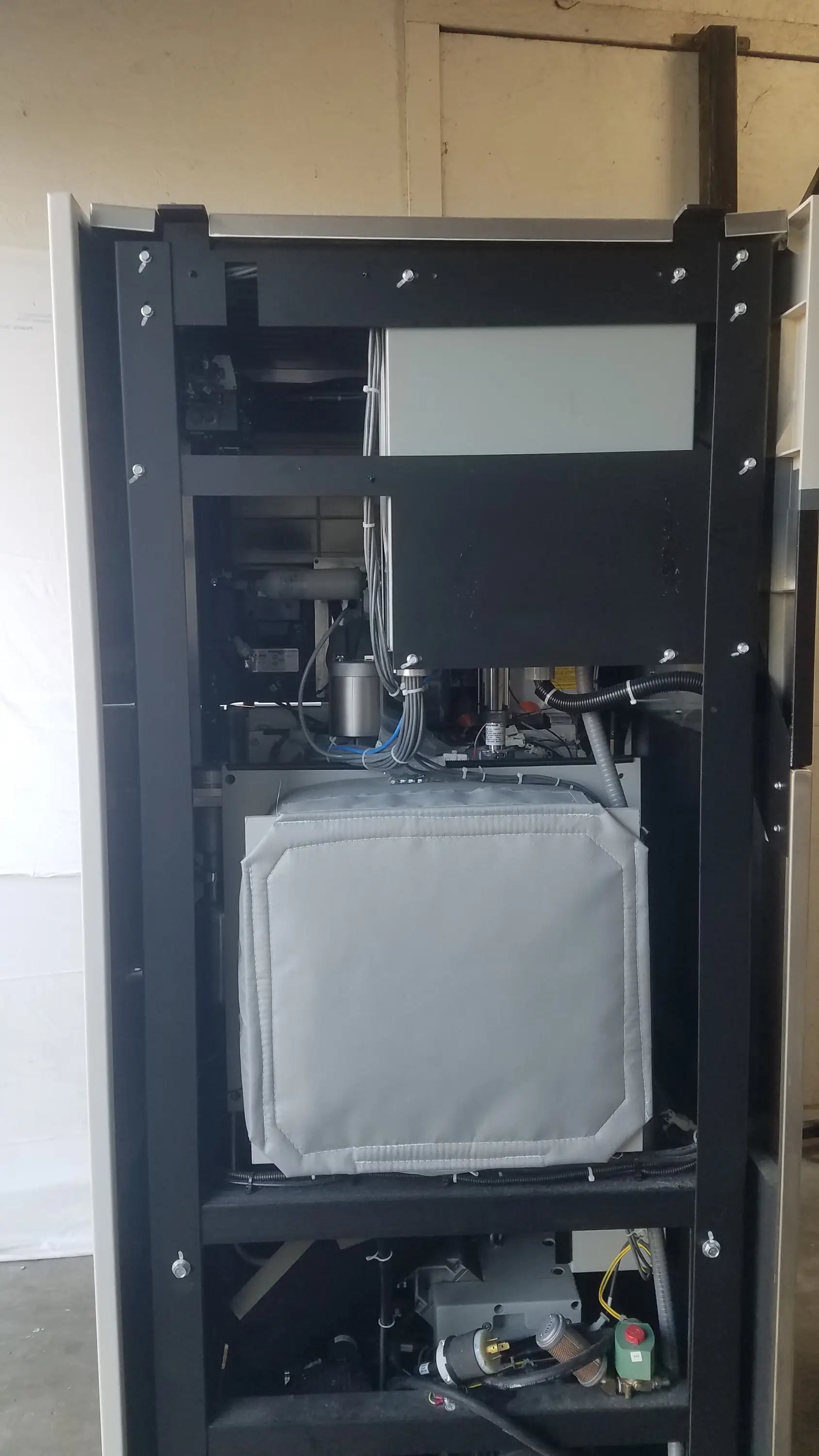 Gray padded rectangular component mounted inside black metal frame of steris v-pro max low temperature sterilization system