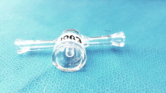 Clear borosilicate glass lab stopcock joint connector with cylindrical chamber and two horizontal arms with black text