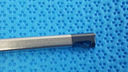 A metallic cylindrical medical equipment tool with a black angled cutting tip for reuse ultrasonic cleaning