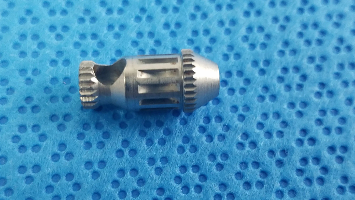 Silver metallic gear with textured teeth in straumann ultrasonic cleaning cassette for reuse medical equipment cleaning