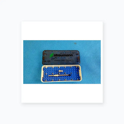 Blue and white plastic Straumann ultrasonic cleaning cassette with silver surgical instruments for reuse medical equipment
