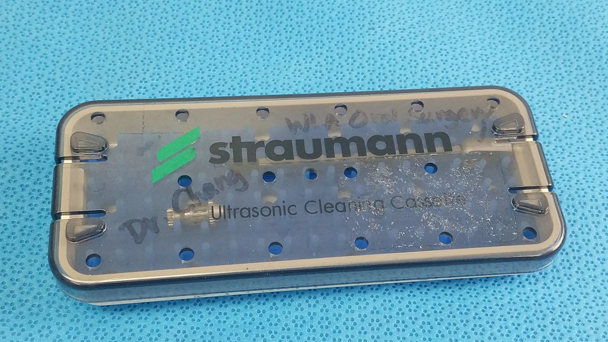 Transparent straumann ultrasonic cleaning cassette with metal frame and circular holes for reuse medical equipment cleaning