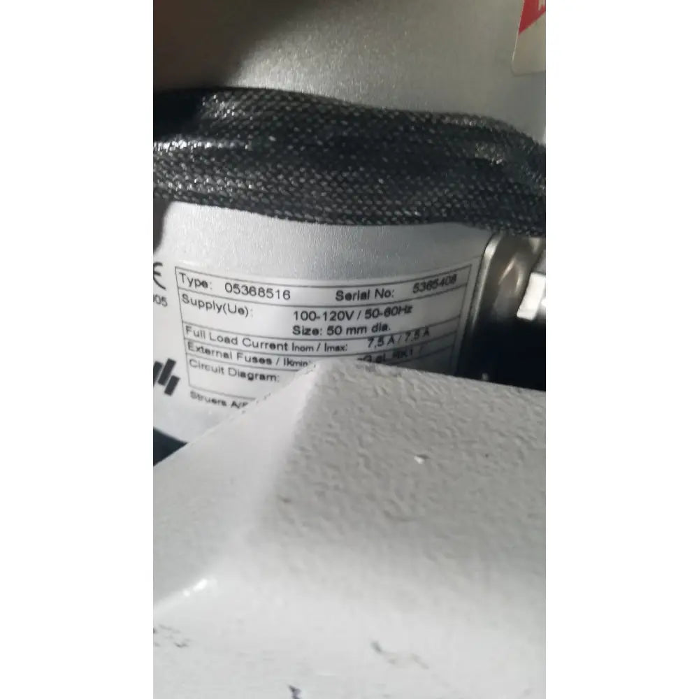Gray textured cylindrical electrical component with white label on struers prontopress-20 dual-cylinder metallographic specimen hot mounting machine
