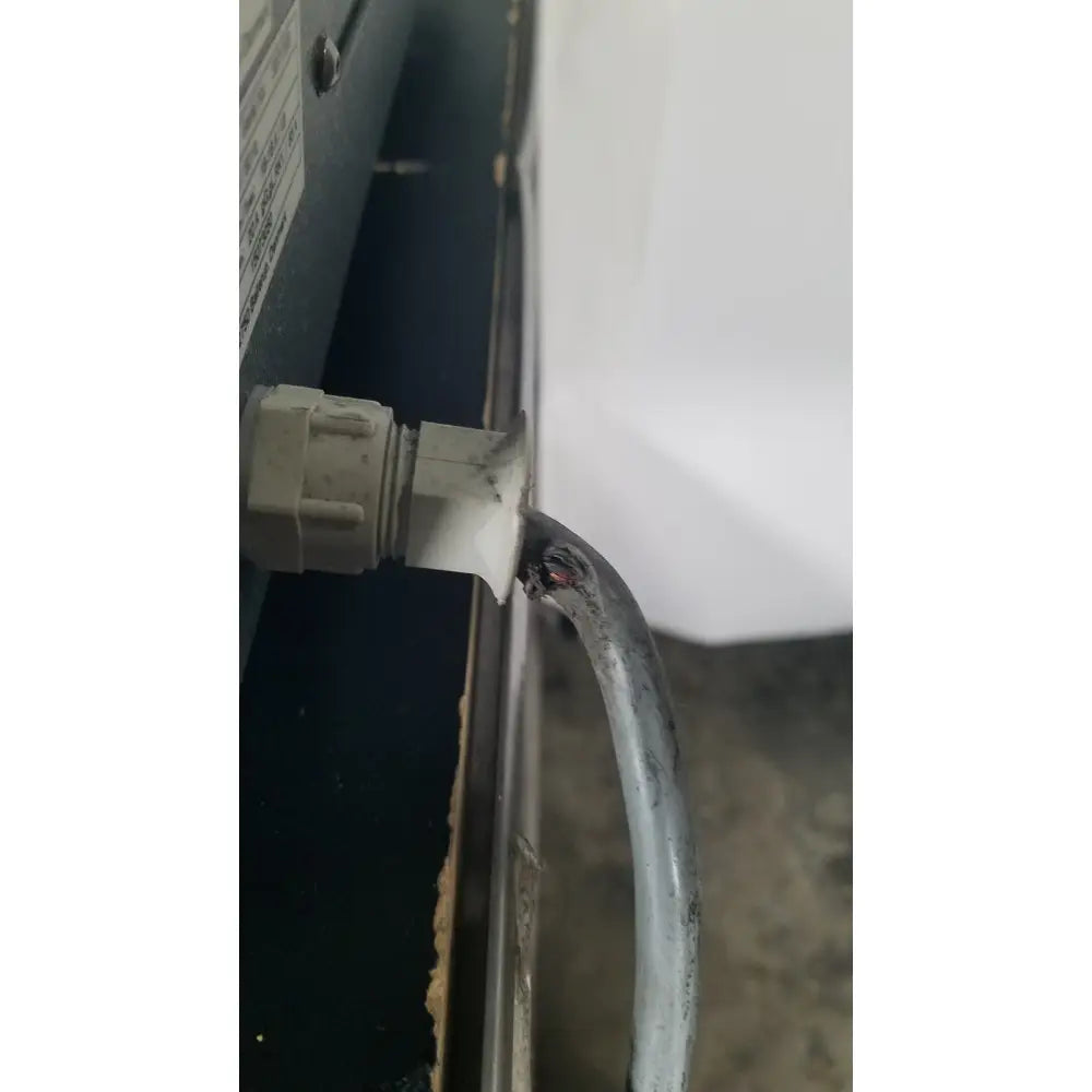 A frayed gray electrical cable with white plastic connector on the back of a struers prontopress-20 dual-cylinder metallographic machine