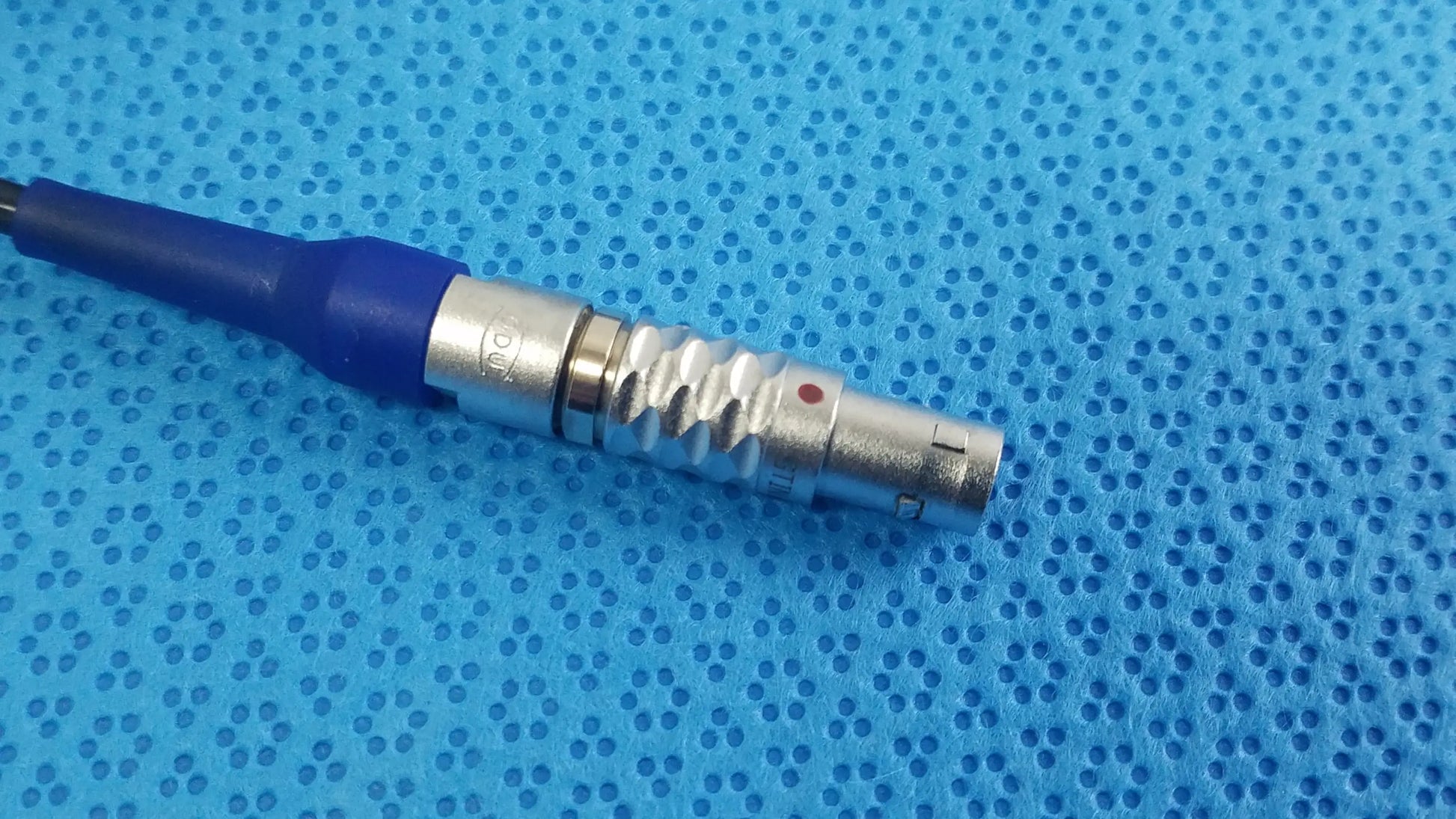 Silver metallic connector with blue insulated cable and textured grip on stryker multigen 2 lightweight sterilization box for reuse medical equipment