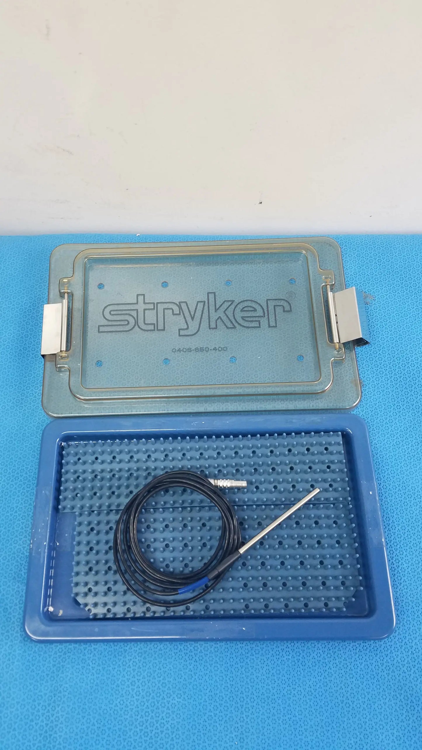 Blue stryker 0406-650-400 sterilization box with black coiled cable and metallic electrode probe for reuse medical equipment
