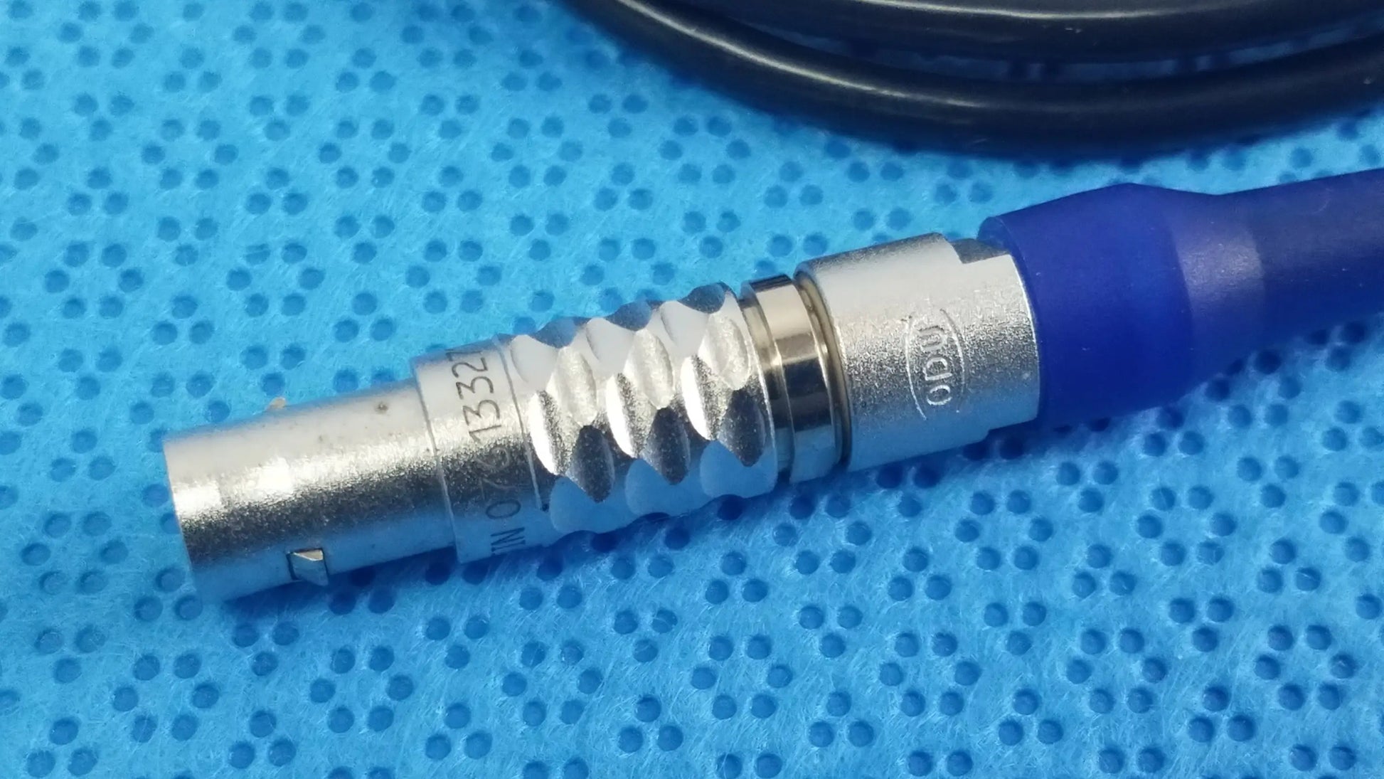 Silver metallic bnc connector with blue strain relief and engraved markings on stryker multigen 2 sterilization box for reuse medical equipment