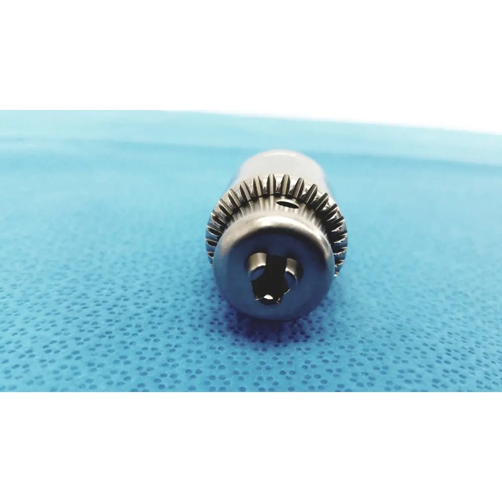 Silver-colored metal drill bit with hexagonal keyed chuck and serrated fluted shaft for reuse medical applications