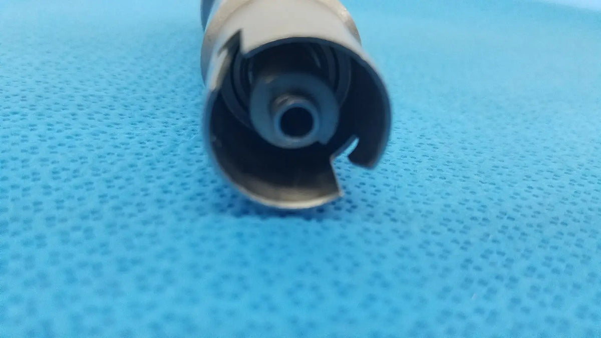 Silver metallic cylindrical component with spiral internal mechanism and cut-out edges for stryker keyless drill reuse medical