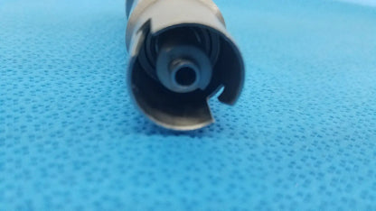 Silver metallic cylindrical component with spiral internal mechanism and cut-out edges for stryker keyless drill reuse medical
