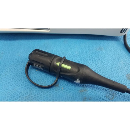 Black rubberized Stryker 1588 AIM HD camera endoscope with green arrow and looped cable for reuse medical procedures