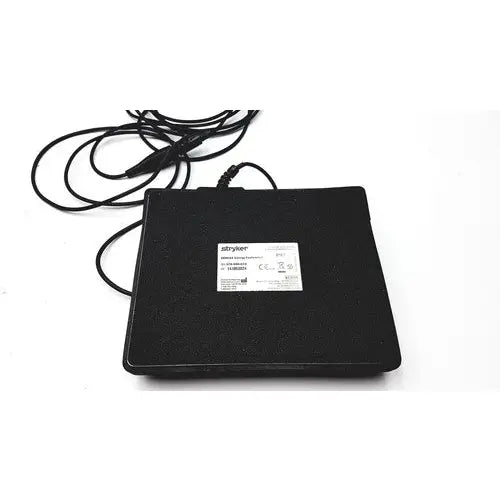 Black rectangular serfas energy footswitch mouse pad with textured surface and white label for reuse medical use