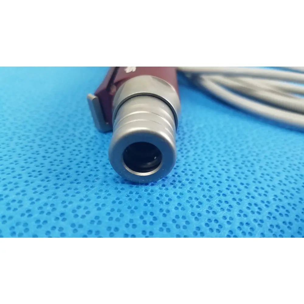 Maroon and silver tps leibinger hummer shaver handpiece with cylindrical lens housing for medical use by Stryker