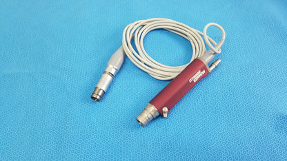 Red and silver Stryker TPS Leibinger Hummer shaver handpiece with coiled white cable for surgical use