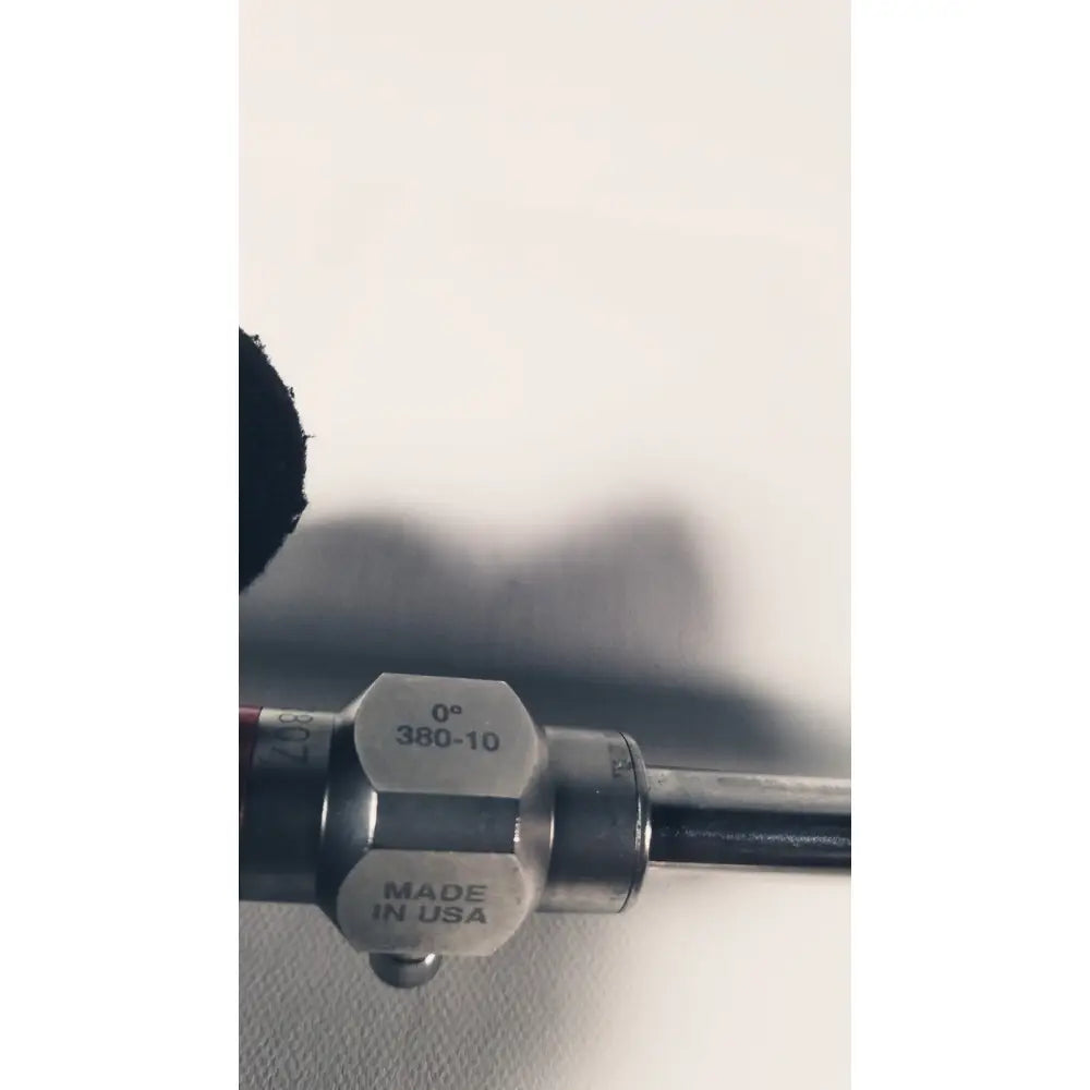 Silver metallic end cap with engraved markings 0° 380-10 made in usa attached to a stryker 380-10mm 0 degree rigid laparoscope