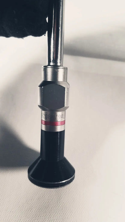 Black and silver Stryker 380-10mm 0 degree rigid laparoscope tip with hexagonal metallic collar and red stripe