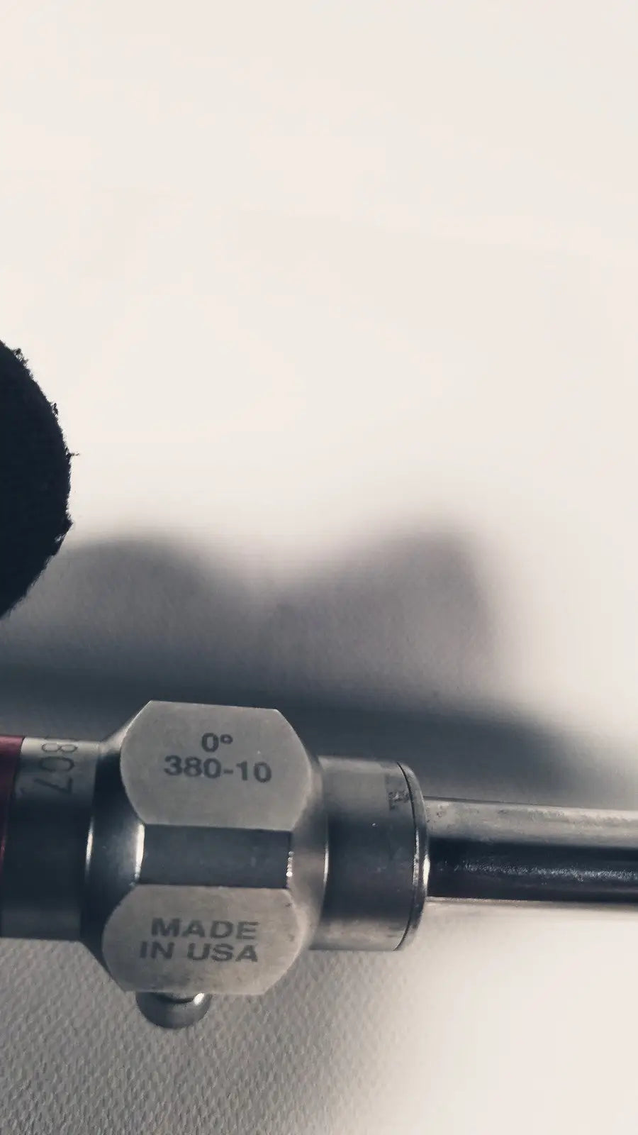 Silver metallic end cap with engraved markings 0° 380-10 made in usa attached to a stryker 380-10mm 0 degree rigid laparoscope