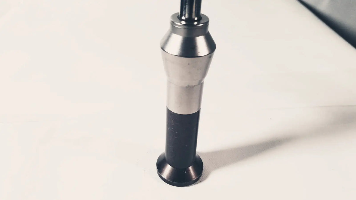 Silver and black impact hammer with cylindrical metallic head and textured grip handle for reuse medical applications
