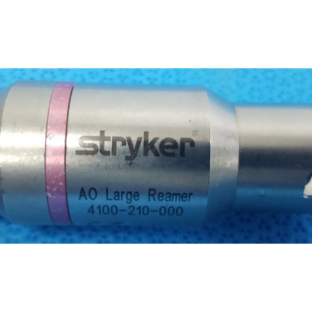 Silver metallic stryker 4100-210-000 large reamer attachment with pink band and black engraved branding