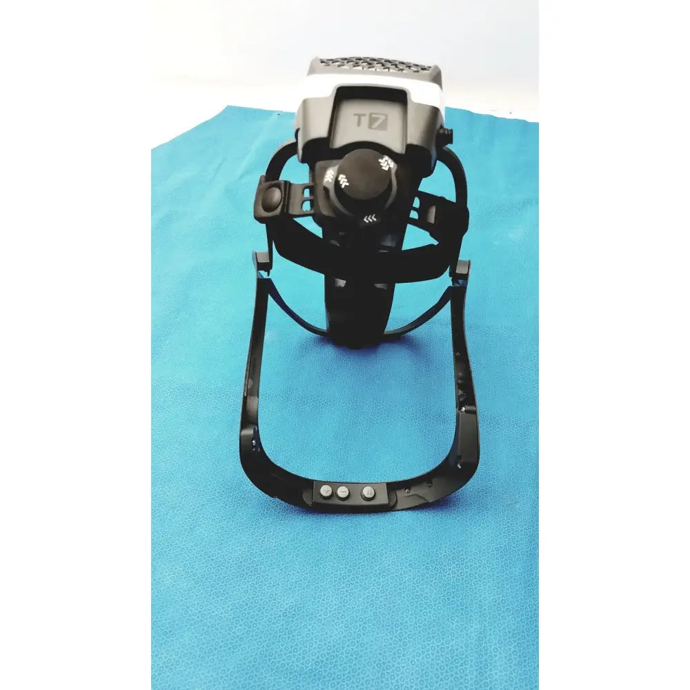 Black and white t7 surgical helmet with adjustable straps and power cord protective headgear control buttons visible