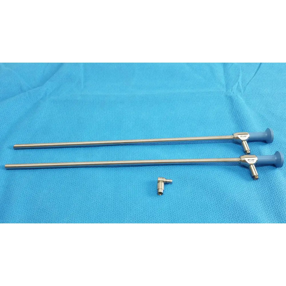 Two metallic ideal eyes 10mm surgical endoscopes with blue ergonomic handles and silver connector on textured blue surface