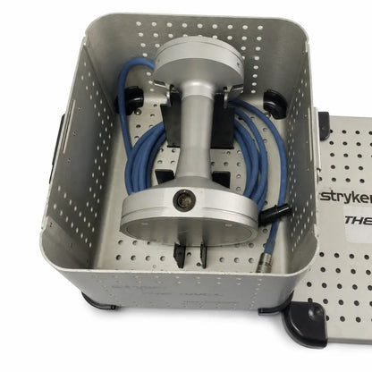 Silver metallic stryker 5400-700-000 bone mill with blue connecting cable housed in perforated sterilization container