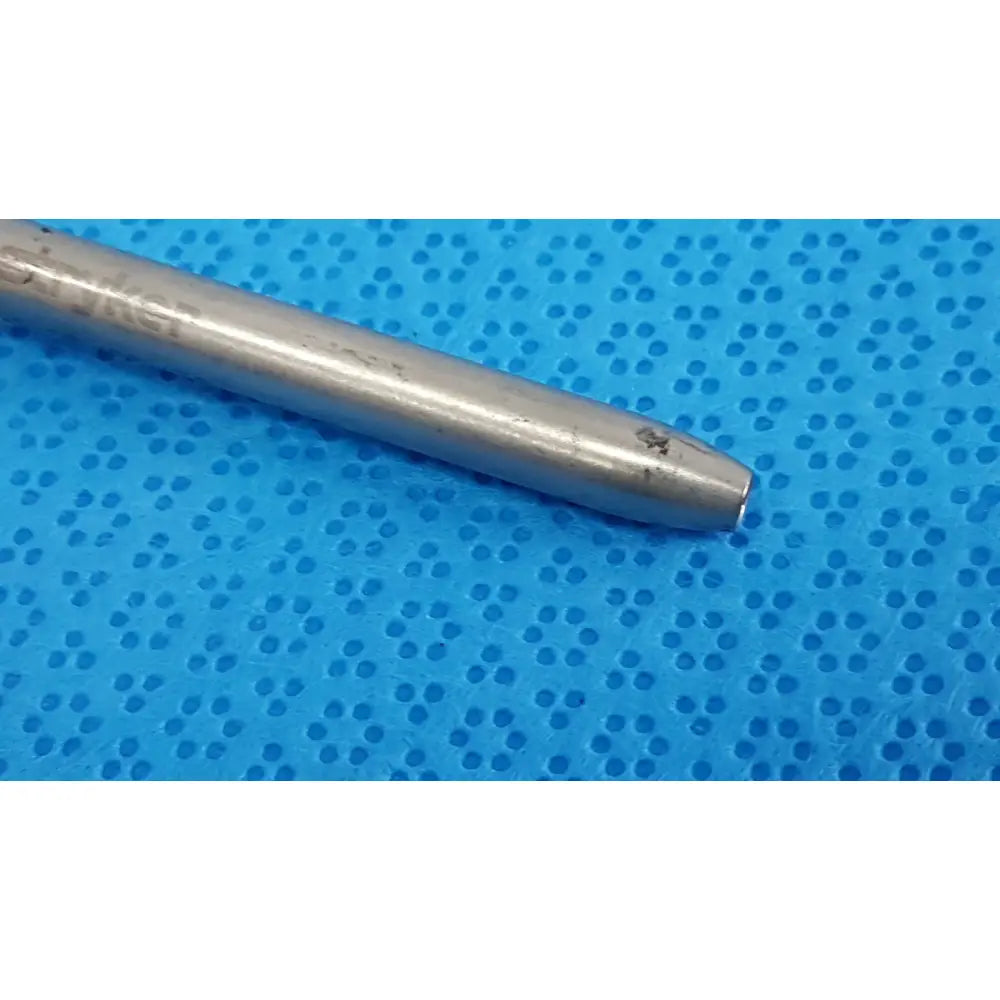 Silver-colored metal cylindrical maestro attachment with engraved text and minor wear for surgical power tool use