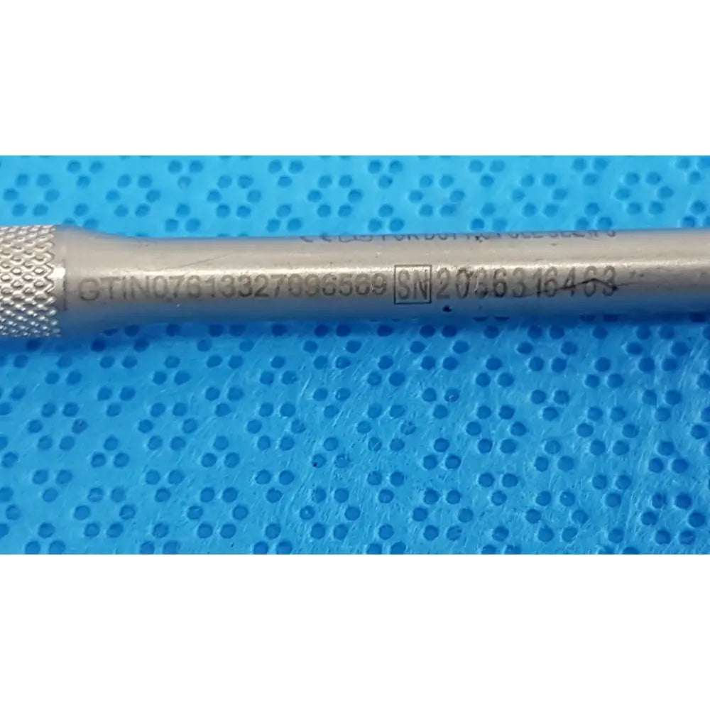 Silver-colored metal maestro attachment with textured grip and engraved serial numbers for surgical power tool use