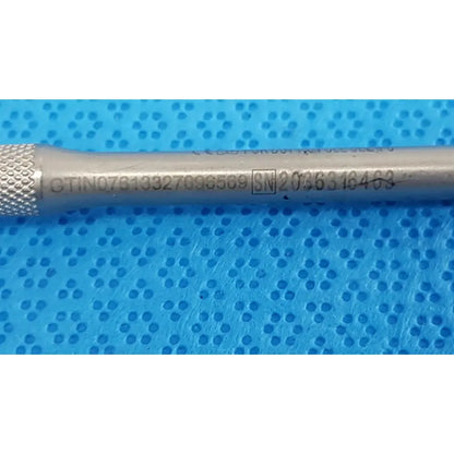 Silver-colored metal maestro attachment with textured grip and engraved serial numbers for surgical power tool use