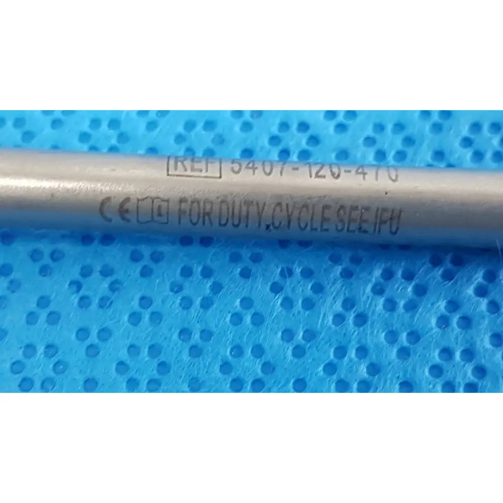 Silver metallic cylindrical maestro attachment with engraved reference and certification for surgical power tool use