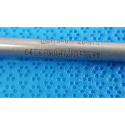 Silver metallic cylindrical maestro attachment with engraved reference and certification for surgical power tool use