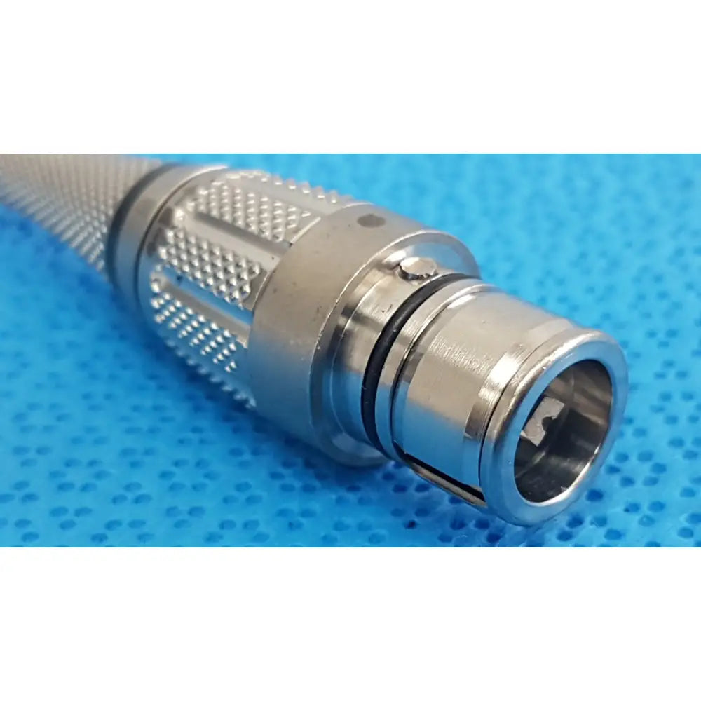 Silver metallic surgical power tool maestro attachment with textured knurled grip and threaded sections for secure connection