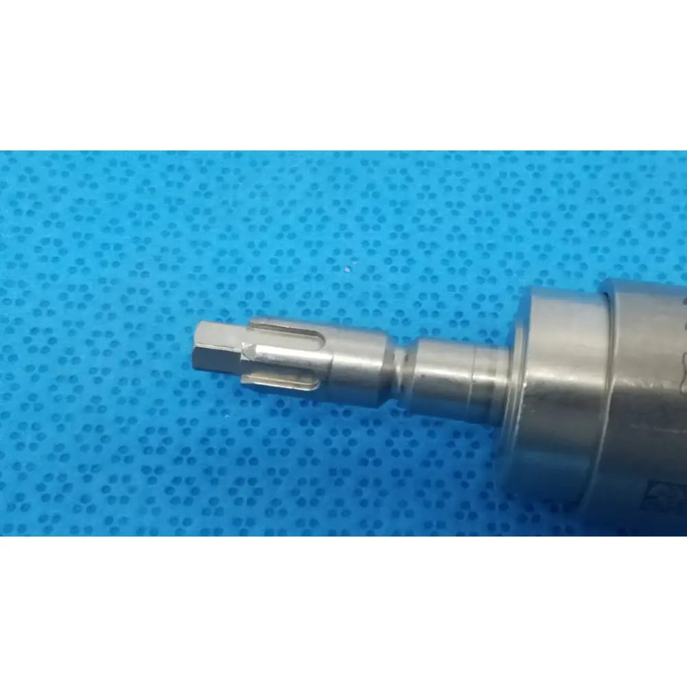 Silver-colored metal drill bit with hexagonal shank and serrated edge for stryker hudson modified trinkle attachment