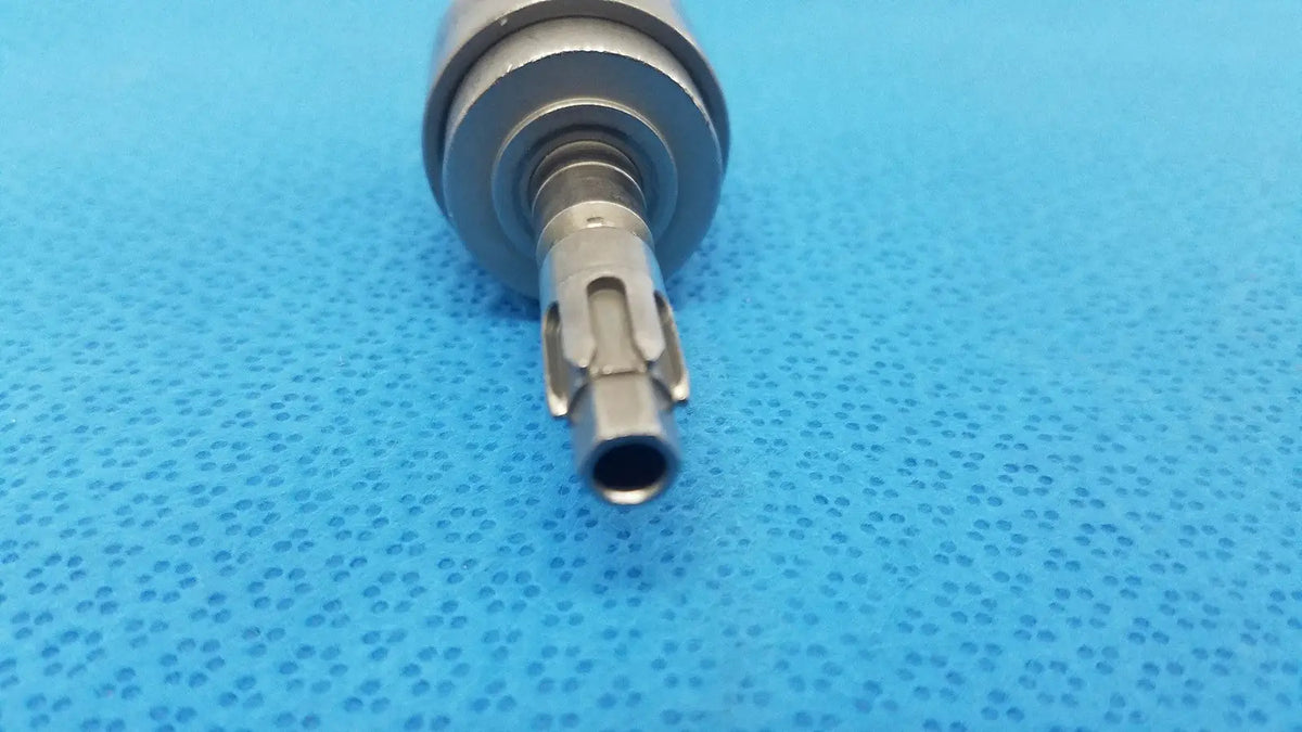 Silver-colored metal dental handpiece with textured cylindrical body and precision-engineered tip for hudson modified trinkle use